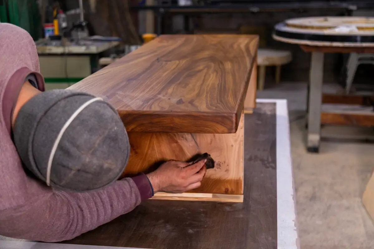 Carpenter cubre una mesa de madera con aceite de linaza